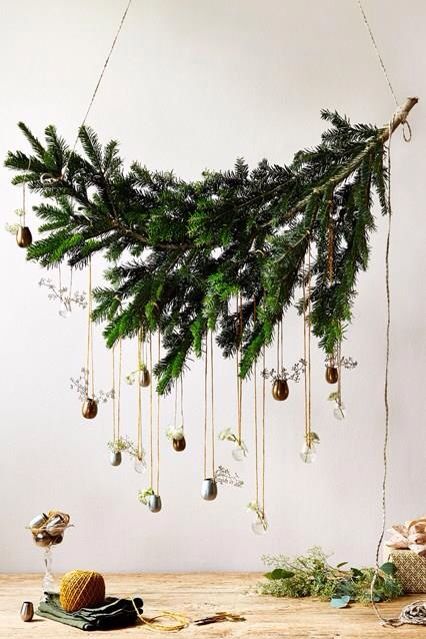 a fresh take on a Christmas wreath made of a fir branch and some little vases with greenery