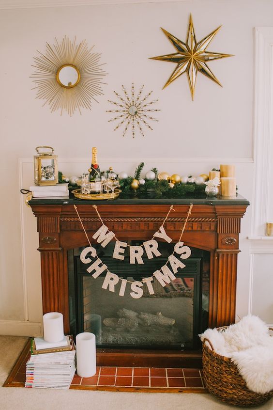 a glam mantel with shiny metallic ornaments, gold candles, a gold lantern and a champagne tray