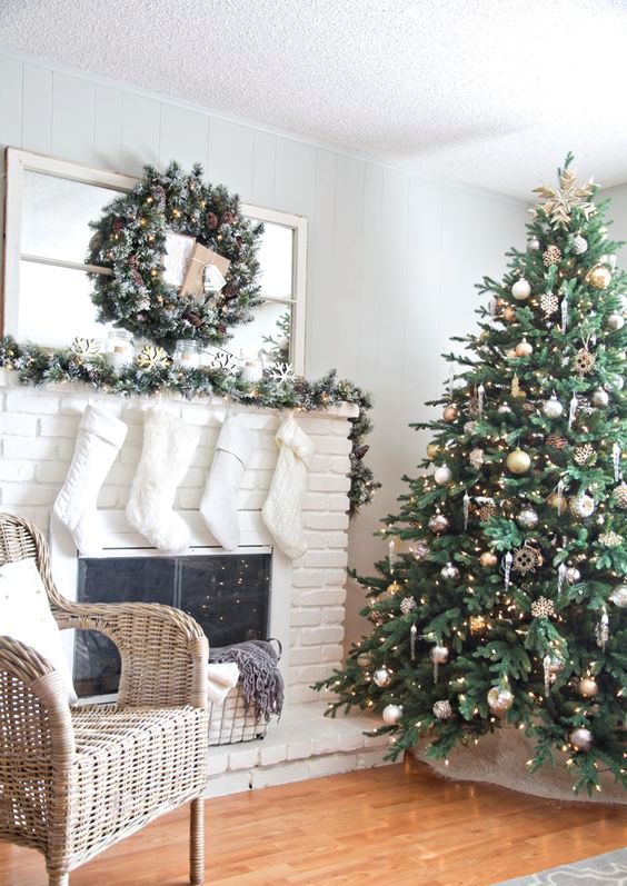a mix of silver and gold ornaments stands out in an emerald Christmas tree