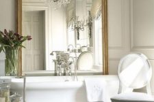 12 an oversized vintage frame mirror and a large crystal chandelier over the tub can be a glam statement