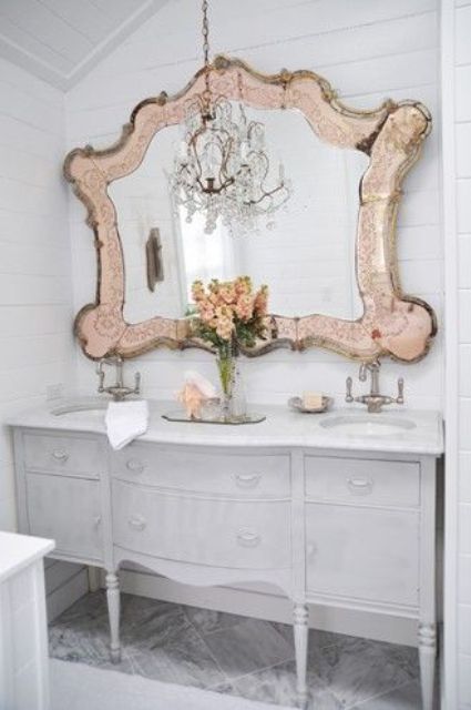 a large mirror in a unique vitnage frame with a metal touch brings chic and glam