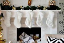 13 a shiny glam mantel with faux fur stockings, Christmas ornament trees and gifts inside the fireplace