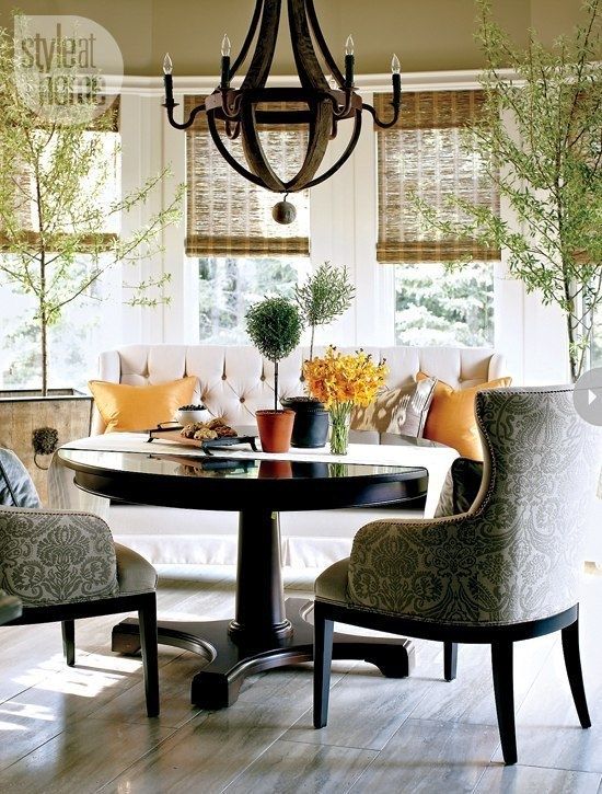 a stylish breakfast or dining zone with upholstered furniture and a round pedestal table with a traditional feel
