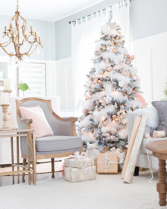 a flocked tree with gold and copper Christmas ornaments and shiny touches
