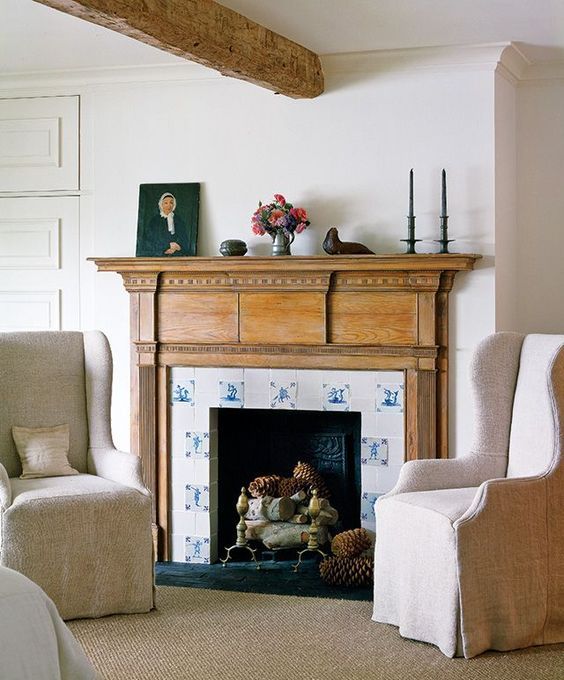 the fireplace is clad with blue and white tiles and wood in a seaside room