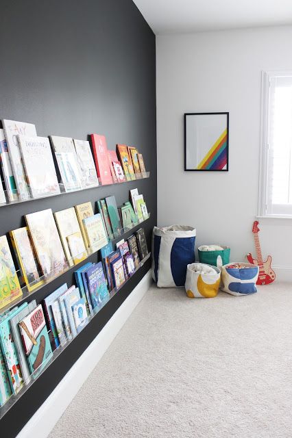 a black statement wall with lots of colorful books on display attract attention to them