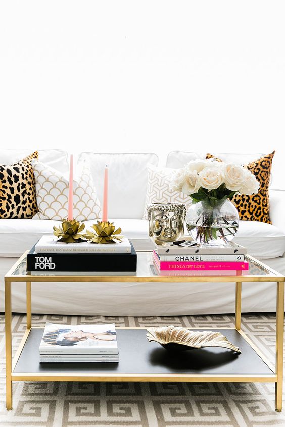 a chic brass coffee table and leopard pillows add glam to the space
