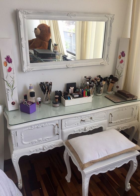 a mirror in a vintage white frame matches a vintage vanity made of a dresser