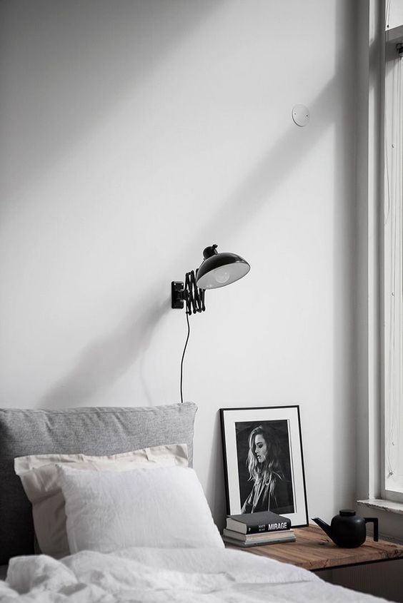 an industrial black wall sconce for a Scandinavian bedroom