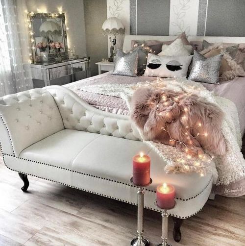 a creamy leather bench and a dusty pink faux fur blanket, a mirrored vanity and sequin pillows