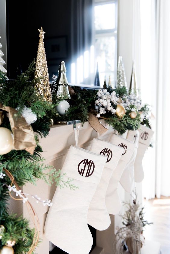 a mantel done with a faux fir garland and metallic Christmas trees in silver and gold