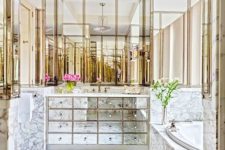 17 a built-in mirrored vanity with many drawers and marble and brass all over for a glam feel