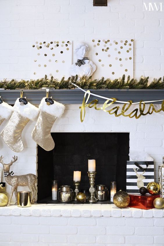 a fun glam mantel with a lit up fir garland, polka dot signs, shiny stockings, metallic decor and a sparkling deer