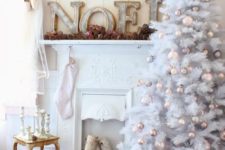 18 a faux mantel decorated with wooden letters, lots of pinecones and a vintage-inspired wreath over it