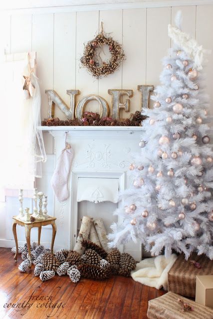 a faux mantel decorated with wooden letters, lots of pinecones and a vintage-inspired wreath over it