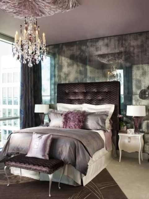 a chocolate upholstered bed and ottoman and a crystal chandelier to make the space girlish