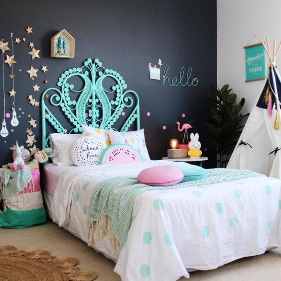 a colorful girl's space is made more peaceful with a black headboard wall