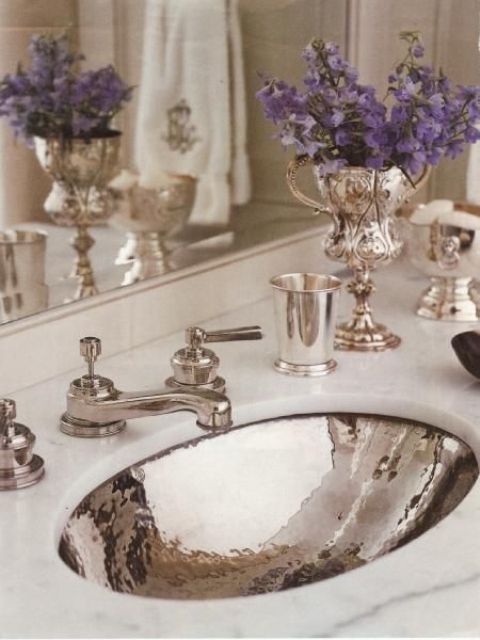 a marble countertop and a shiny silver sink with matching faucets looks very feminine, refined and chic
