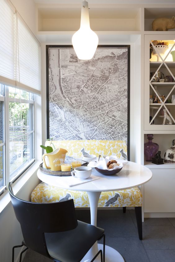 a modern bold breakfast nook by the window done in grey and yellow and with a map mural on the wall