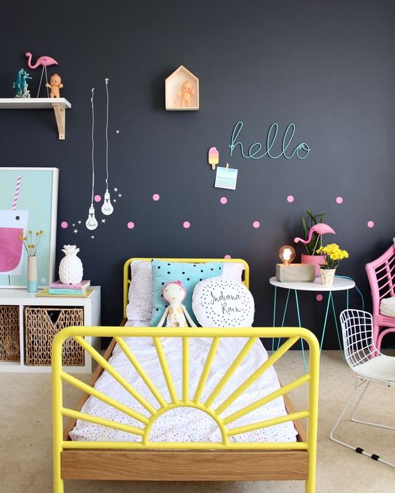 A colorful space is calmed down with a black statement wall, which is made more cheerful with bold accessories