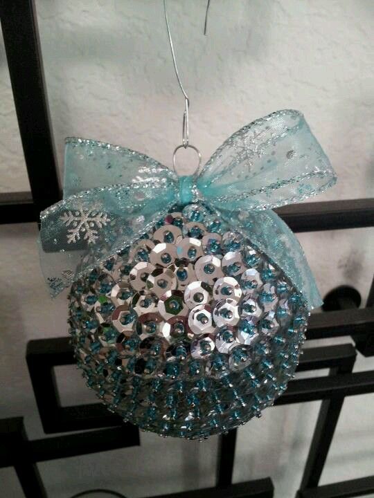 a silver and light blue sequin ball ornament with a large light blue ribbon bow