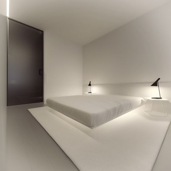 a very clean minimal bedroom with a floating bed and additional lighting under it