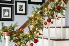 20 an evergreen garland with lights, stars and red ornaments to line up the stairs