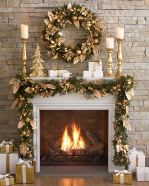 an evergreen and gold fruit and leaf garland and wreath for a holiday fireplace