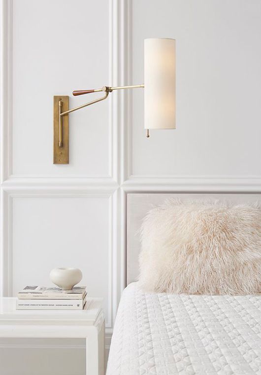a chic sconce with a tube shadde and a brass base looks very elegant