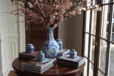 22 a vintage rich-colored wood table serves as a display for books and blue china and makes th einterior refined
