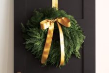 22 an evergreen wreath with gold ribbon and a bow looks natural and very cute