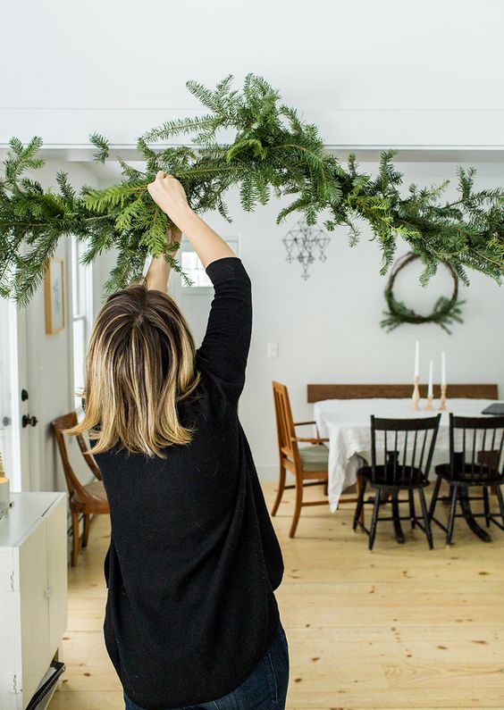 a simple evergreen garland attached over the entry to the dining space