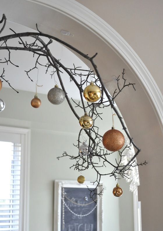 decorate an archway with branches and mixed metal ornaments of different sizes and looks