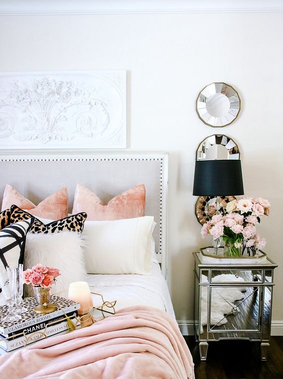 a chic mirrored nightstand and some round mirrors make the bedroom more feminine and shiny