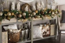 24 an evergreen garland with gold, copper and silver large ornaments is great for decorating a console