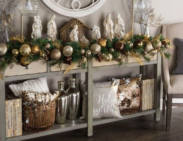 an evergreen garland with gold, copper and silver large ornaments is great for decorating a console