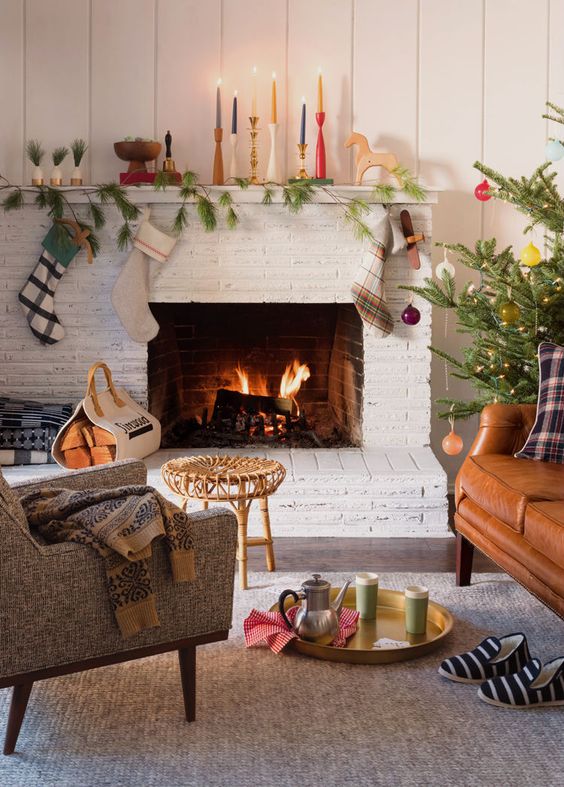 colorful candles, a pine garland, some plaid stockings and ornaments is a simple arrangement to make
