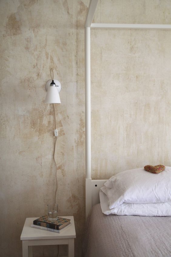 a simple white sconce with a classic shape will fit most bedroom styles