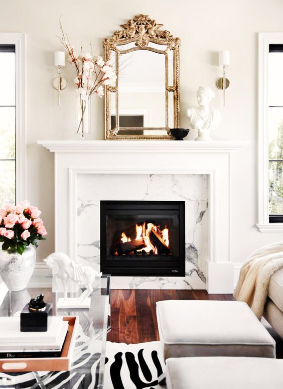 a glam clad fireplace, a zebra print rug, a vintage mirror and an acrylic table to add a refined glam feel