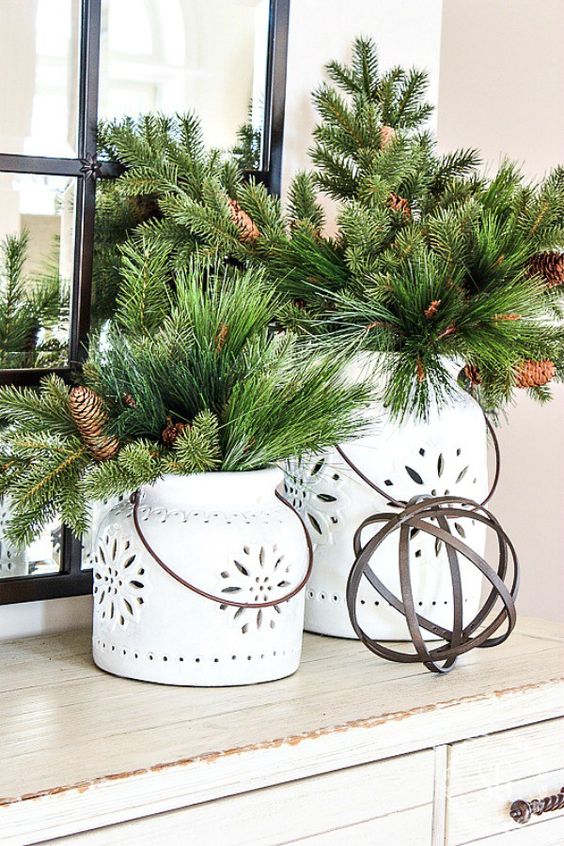 white candle lanterns with faux evergreens and pinecones for a rustic winter feel