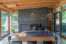 01 The beautiful living room features a large reclaimed wood clad fireplace and glazed walls from both sides to catch the views