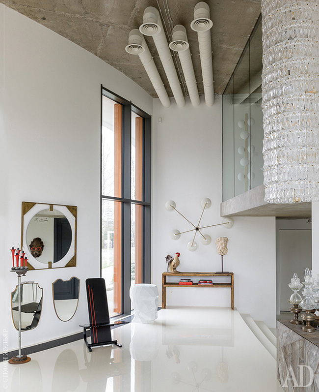 The entryway of this home strikes with arworks, an oversized crystal chandelier and eye catchy mirrors