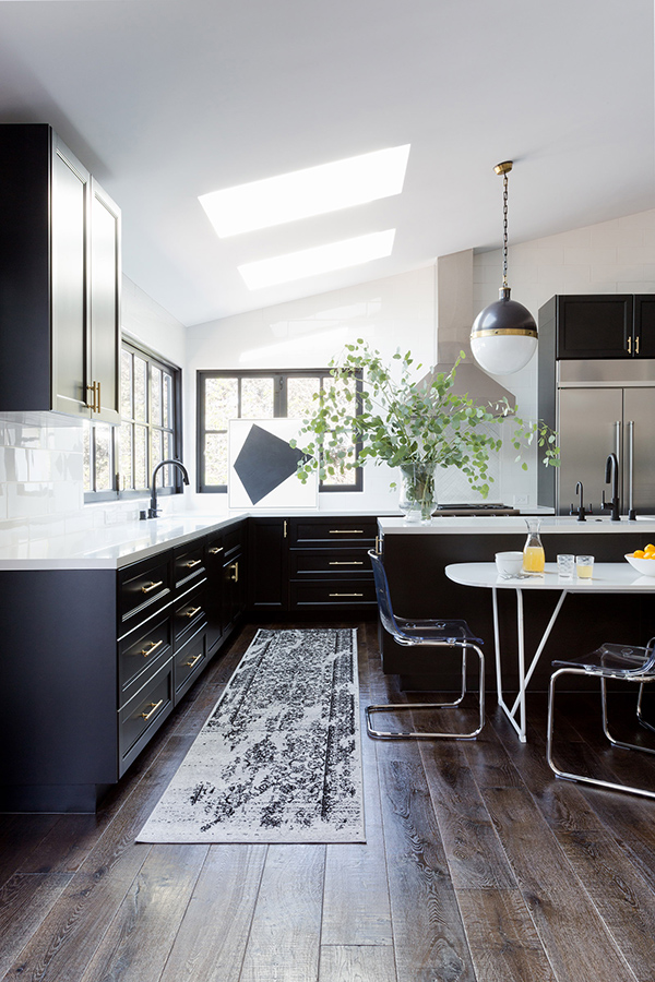 The kitchen is done in the classic color palette of black and white, with skylights and windows to bring natural light in
