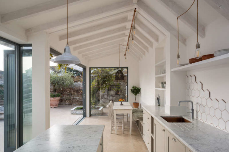 This airy white kitchen and dining zone is opened to outdoors as much as possible and feels very light and airy