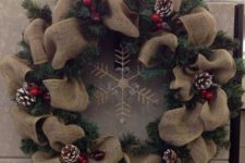 02 a burlap and evergreen wreath with a rhinestone snowflake, snowy pinecones and cranberries