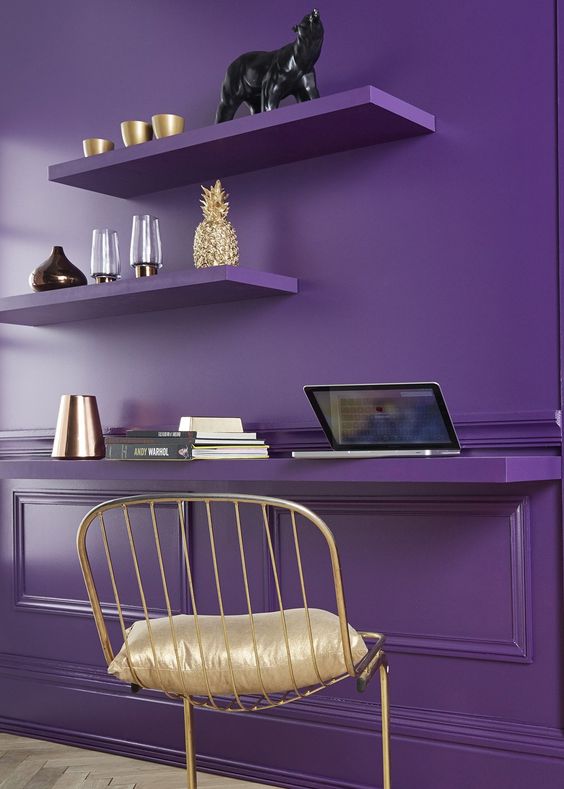 a violet statement wall with shelves and a floating desk