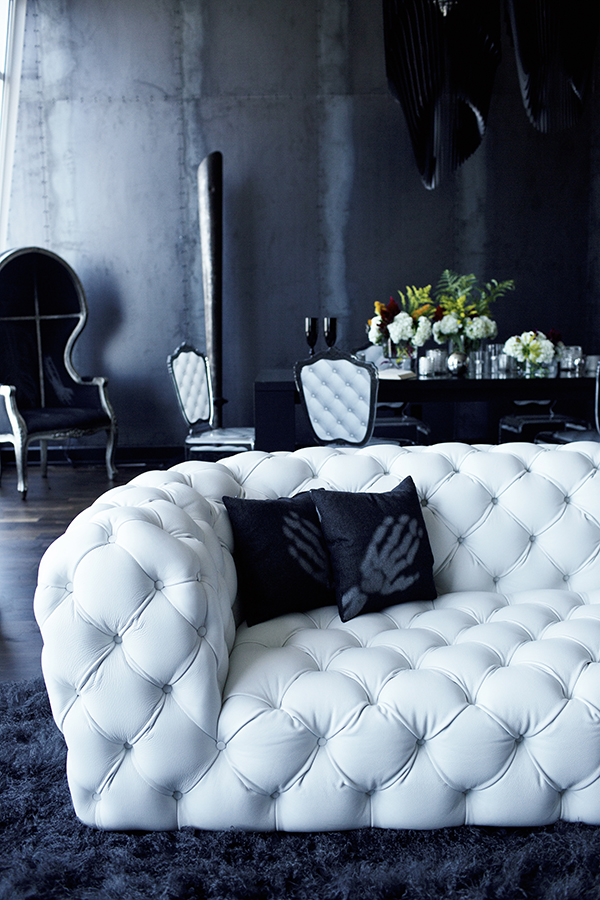 The space is done in black and very dark grey, with white upholstered furniture