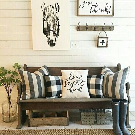 a barn-styled entryway with buffalo check pillows and calligraphy touches