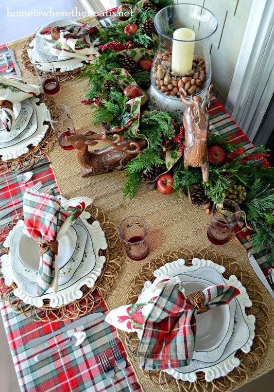 a lush evergreen garland with pinecones, apples, deer figurines and a candle lantern with nuts