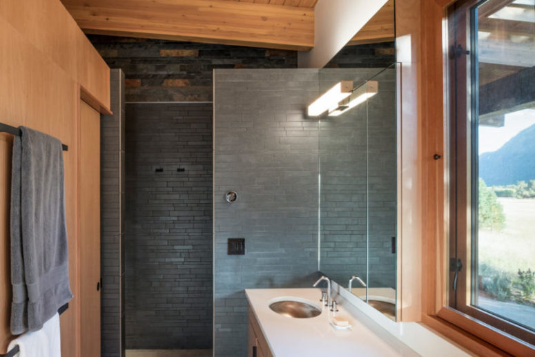 The bathroom is done with black stone and rich-colored wood, it's small yet very convenient